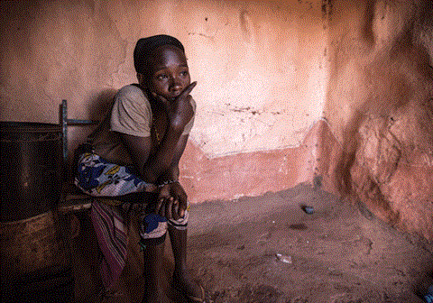 Ei jente fra Kenya sitter i et rom med jordvegger og ser tankefull ut. Illustrasjonsfoto: Rory Sheldon
