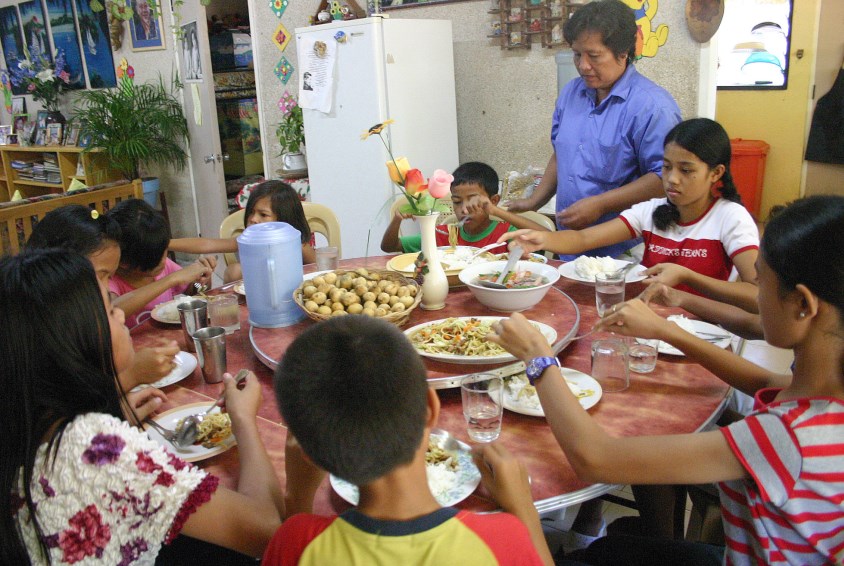 Familien samles for måltider i barnebyen i Cebu.