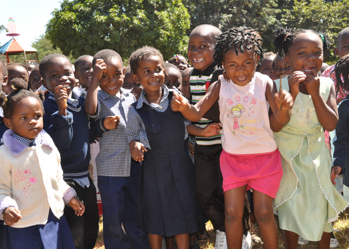 Glade barn fra SOS-barnebyers barnehage i Lilongwe som smiler og vinker. Malawi. Foto: Turid Weisser