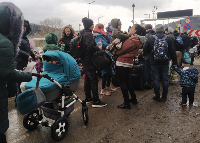 Familier med barn står i kø ved en grenseovergang. Foto: SOS-barnebyer