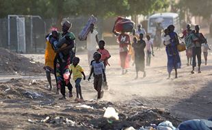 Sudan: Familier med barn flykter fra kampene. Foto: AFP