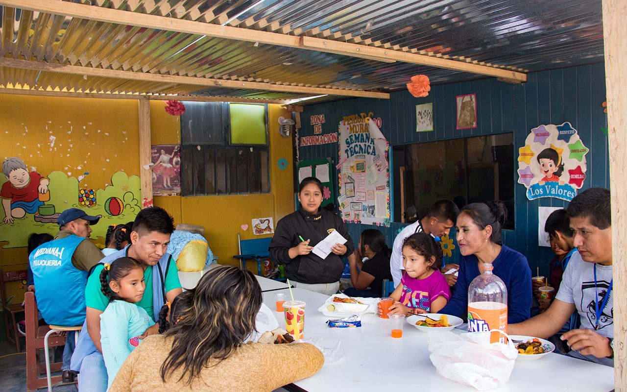 Barn og foreldre spiser og prater sammen. Foto: Alejandra Kaiser