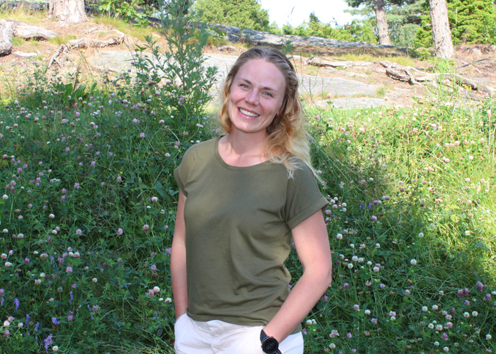 Maren Frogner Werner står i en blomstereng, hun har grønn t-skjorte og lyse bukser. Foto: Privat